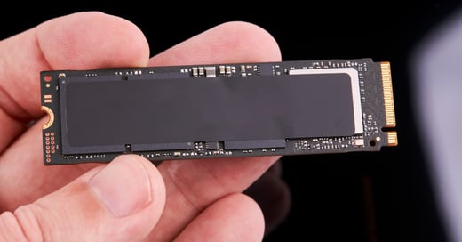 A human hand holding a NAND flash memory module