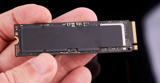 A human hand holding a NAND flash memory module